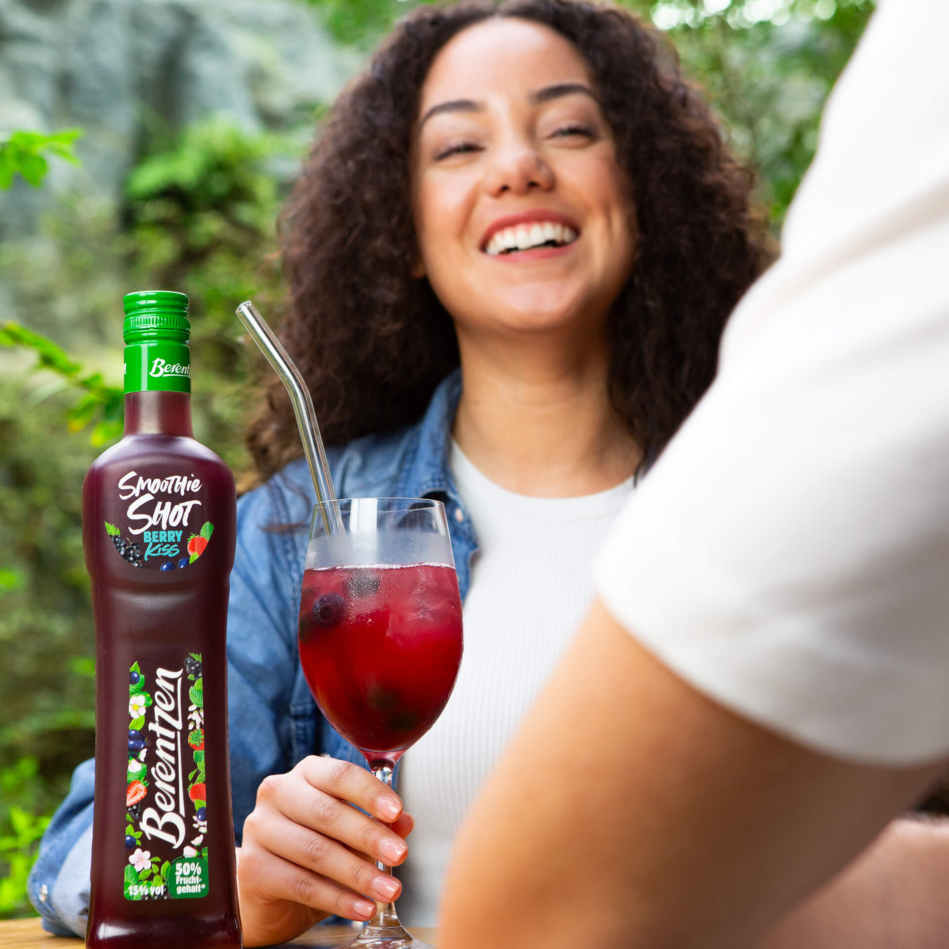 Frau hält Glas mit Berentzen Smoothie Shot Berry