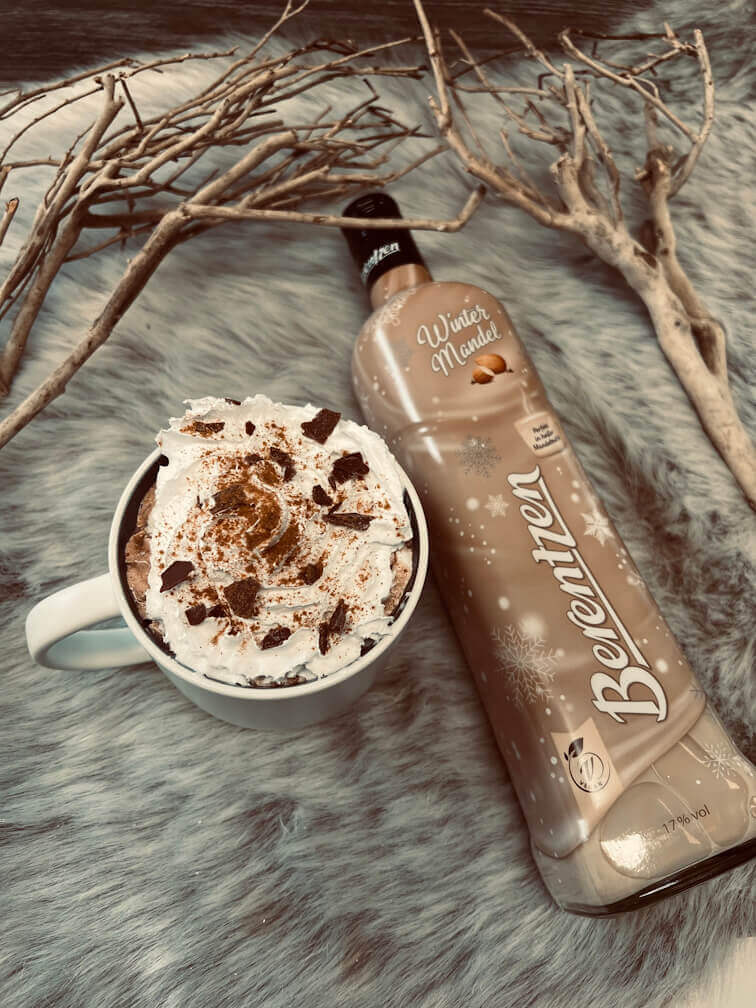 Berentzen Winter Mandel Vegan Flasche Berentzen Winter Mandel liegt neben einer Tasse Kakao