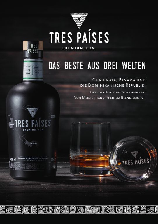 Werbeposter Tres Países Premium Rum in Holzoptik neben einem gefüllten Tres Países Glas