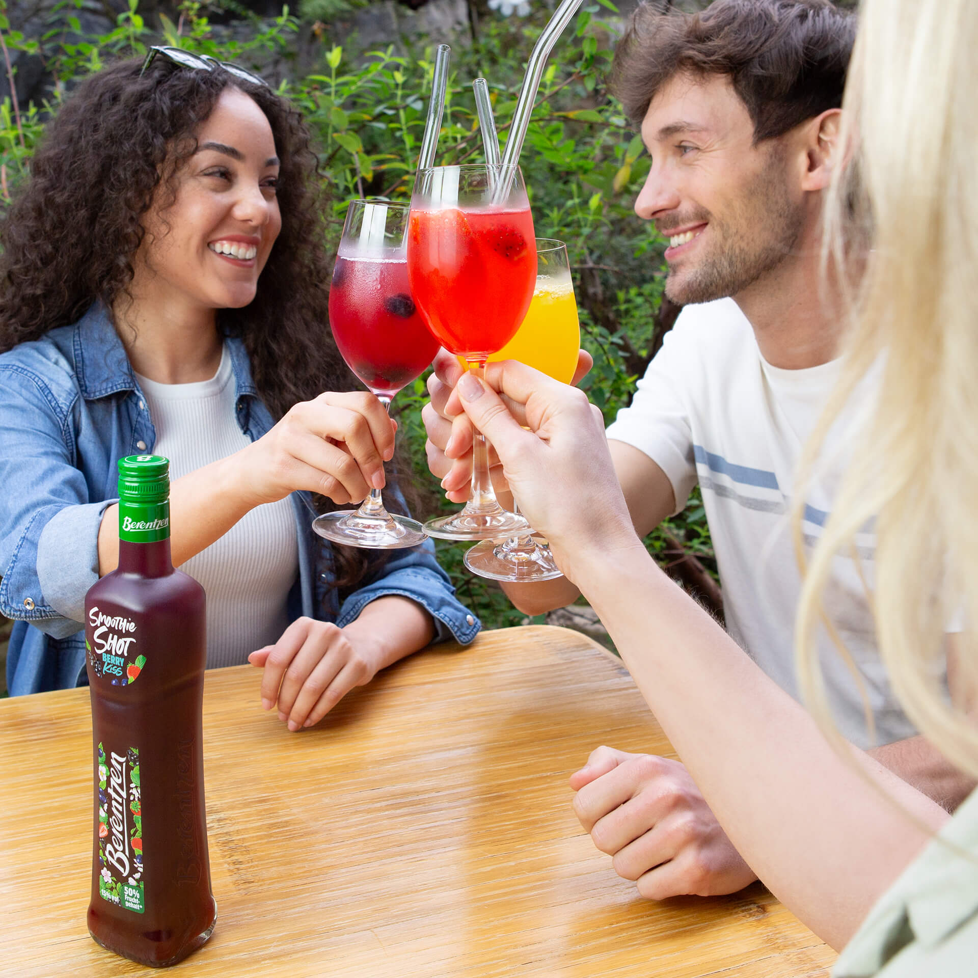 Gruppe stößt mit Gläsern von Berentzen Smoothie Shots an