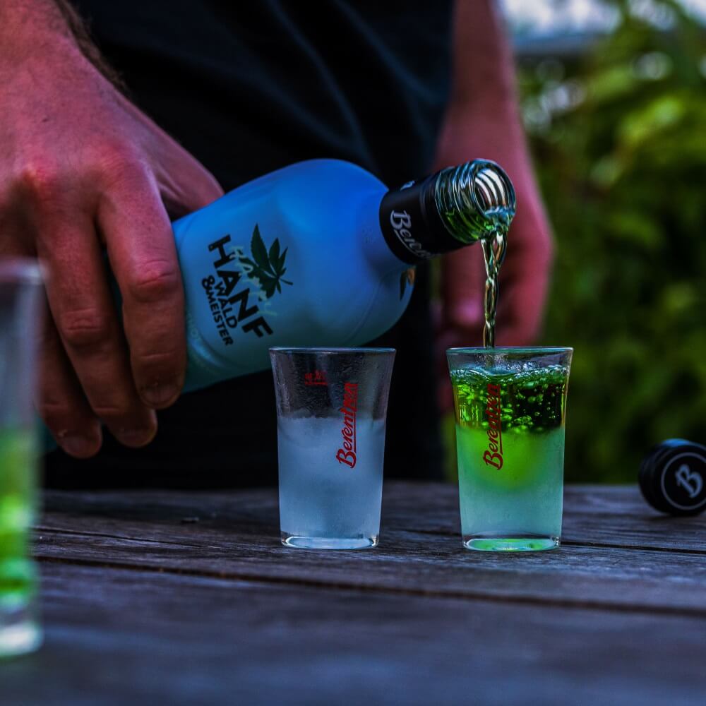 Berentzen Stamper Mann schenkt Berentzen Hanf Likör in Stamper Glas ein