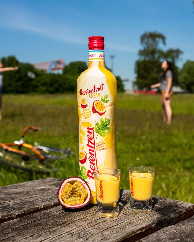 Berentzen Passionfruit Cream Flasche Berentzen Passionfruit Cream auf einem Tisch mit zwei Shotgläsern