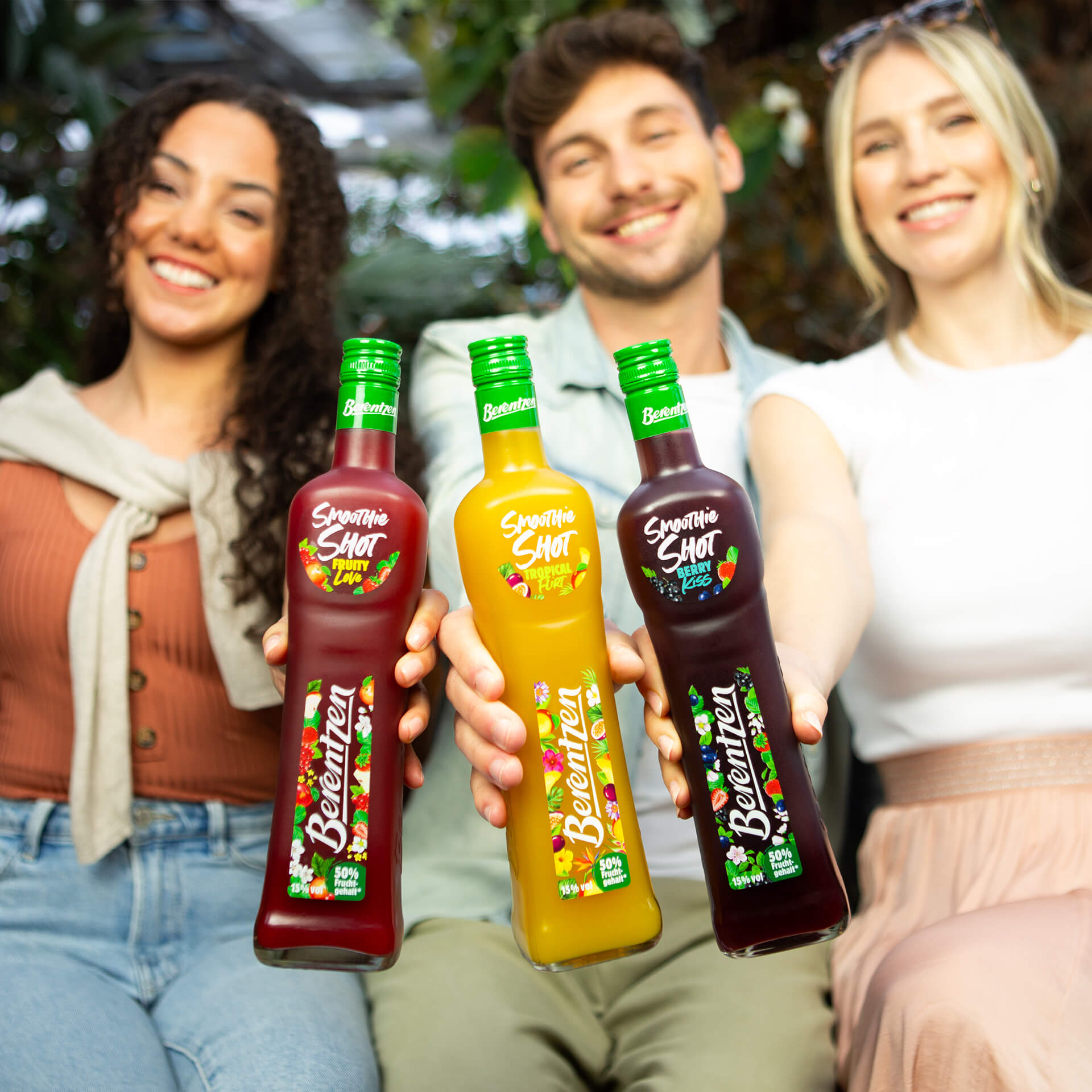 Freundesgruppe hält Berentzen Smoothie Shots Flaschen
